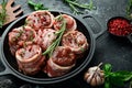 Raw meat medallions wrapped in bacon. in a pan, ready to cook. On a concrete background. Royalty Free Stock Photo