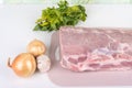 Raw meat, onion and garlic and a bunch of parsley on the kitchen table. Royalty Free Stock Photo