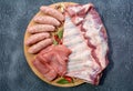Raw meat products.Barbecue pork ribs, steaks, grilled sausages,minced meat, garnished with spices on a round wooden chopping board Royalty Free Stock Photo
