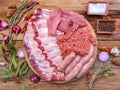 Raw meat products.Barbecue pork ribs, steaks, grilled sausages,minced meat, garnished with spices on a round wooden chopping board Royalty Free Stock Photo