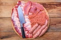 Raw meat products.Barbecue pork ribs, steaks, grilled sausages,minced meat, garnished with spices on a round wooden chopping board Royalty Free Stock Photo