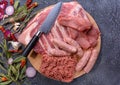 Raw meat products.Barbecue pork ribs, steaks, grilled sausages,minced meat, garnished with spices on a round wooden chopping board Royalty Free Stock Photo