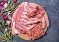 Raw meat products.Barbecue pork ribs, steaks, grilled sausages,minced meat, garnished with spices on a round wooden chopping board Royalty Free Stock Photo