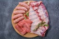 Raw meat products.Barbecue pork ribs, steaks, grilled sausages,minced meat, garnished with spices on a round wooden chopping board Royalty Free Stock Photo