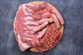 Raw meat products.Barbecue pork ribs, steaks, grilled sausages,minced meat, garnished with spices on a round wooden chopping board Royalty Free Stock Photo