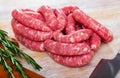 Raw meat sausages for frying on wooden desk Royalty Free Stock Photo