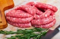 Raw meat sausages for frying on wooden desk Royalty Free Stock Photo