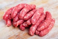 Raw meat sausages for frying on wooden desk Royalty Free Stock Photo