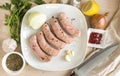 Raw meat sausages with spices, top view, onion ,garlic, parsley, knife, lemon