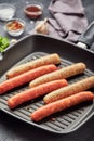 Raw meat sausages on a square grill pan Royalty Free Stock Photo