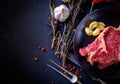 Raw meat steak entrecote on the plate with spice on the dark tab Royalty Free Stock Photo