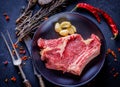 Raw meat steak entrecote on the plate with spice on the dark tab Royalty Free Stock Photo