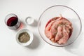 Raw meat, turkey in red wine, rosemary and salt marinade in a glass bowl on a white background