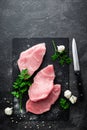 Raw meat, turkey steak on black background, top view