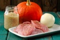 Raw meat, whole pumpkin, onion and rice with pepper mill Royalty Free Stock Photo