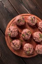 Raw meatballs, with micro greenery, on a cutting board, homemade, rustic, no people,