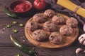 Raw meatballs, with micro greenery, with spices and ingredients, on a wooden table, homemade, rustic, no people,