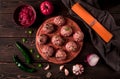 Raw meatballs, with micro greenery, with spices and ingredients, on a wooden table, homemade, rustic, no people,