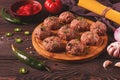 Raw meatballs, with micro greenery, with spices and ingredients, on a wooden table, homemade, rustic, no people,