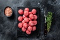 Raw meatballs from minced beef and pork meat with thyme. Wooden background. Top view