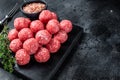 Raw meatballs from minced beef and pork meat with thyme. Wooden background. Top view. Copy space