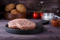 Raw minced beef meat burger cutlets on dark wooden background Royalty Free Stock Photo