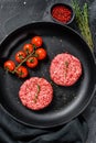 Raw minced beef meat cutlets, patty in a pan. Black background. Top view Royalty Free Stock Photo