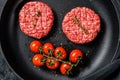 Raw minced marble beef meat cutlets in a pan. Black background. Top view Royalty Free Stock Photo