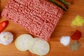 Raw minced meat beef with various spices on a wooden board