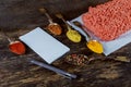 Raw minced meat beef with various spices on a wooden board Royalty Free Stock Photo