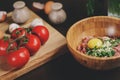 Raw minced meat with egg, herbs and fresh tomatoes on wooden table. Ingredients for cooking meat balls or loaf Royalty Free Stock Photo