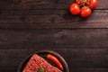 Raw minced meat on paper, ingredients for burger with tomato, pepper, onion, spices and seasonings on black background. Top view