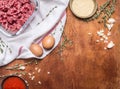 Raw minced meat in transparent bowl with breadcrumbs and eggs tomato sauce with garlic herbs on a white napkin on rustic woode Royalty Free Stock Photo