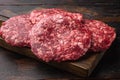 Raw Minced Steak Burgers from Beef Meat, on old dark  wooden table background Royalty Free Stock Photo