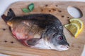 Raw mirror carp with peppers and lemon on cutting board. Cooking fish Royalty Free Stock Photo