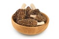 raw morel mushroom in wooden bowl isolated on white background with full depth of field Royalty Free Stock Photo