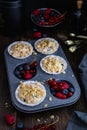 Raw muffin dough with blueberry, raspberry and red currant on rustic wooden table