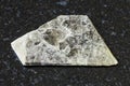 Raw muscovite common mica on black granite Royalty Free Stock Photo