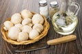 Raw mushrooms in wicker basket, salt, pepper, vegetable oil, knife