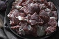 Raw mutton cut into medium pieces, lay on a plate, surrounded by garlic, burlap napkin, and a knife Royalty Free Stock Photo