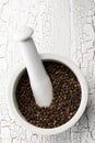 Raw, natural, unprocessed black pepper peppercorns in mortar