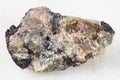 raw Nepheline stone with Ilmenite vein on white