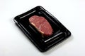 Raw New York strip steak  in black vacuum package, isolated on white background Royalty Free Stock Photo