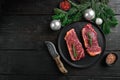 Raw New York striploin beef steak to the Christmas and New Year, on black wooden table background, top view flat lay, with copy