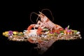 Raw Norway lobster with vegetables on a black background with reflection