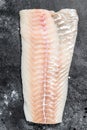 Raw Norwegian skrei cod fish fillet. Black background. Top view Royalty Free Stock Photo