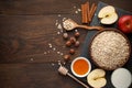 Raw oat flakes in bowl with various ingredients for breakfast on the dark rustic wooden background. Royalty Free Stock Photo