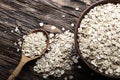 Raw oatmeal flakes in a clay plate on wooden background. healthy carbohydrate breakfast.