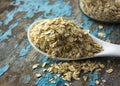 Raw oatmeal is scattered on the desk of the bank in which the oat flakes are stored. blue background in the style of Shabby Chic. Royalty Free Stock Photo