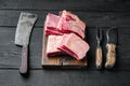 Raw Organic Beef Short Ribs Ready to Cook, and old butcher cleaver knife, on black wooden table background